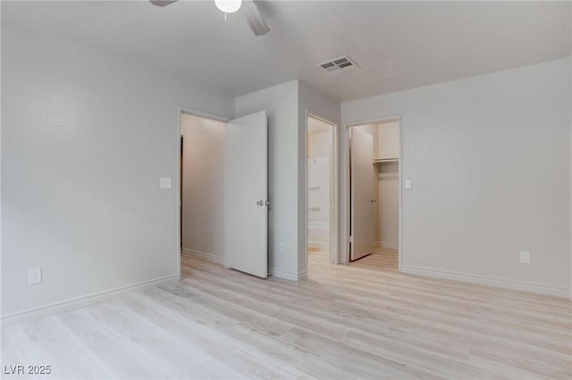 unfurnished bedroom featuring a ceiling fan, baseboards, visible vents, and wood finished floors