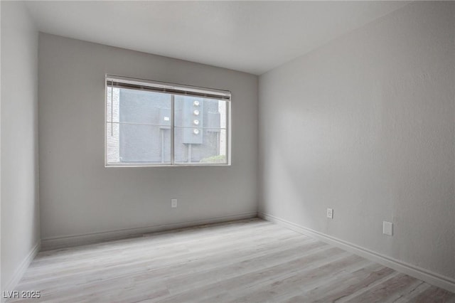 empty room featuring wood finished floors and baseboards