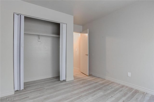 unfurnished bedroom with a closet, baseboards, and wood finished floors