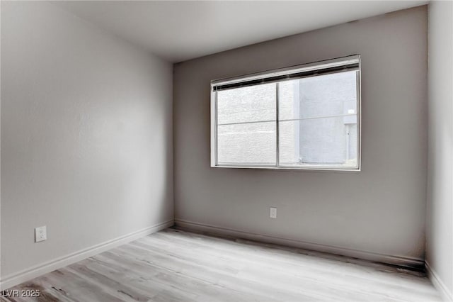 spare room with light wood-style flooring and baseboards