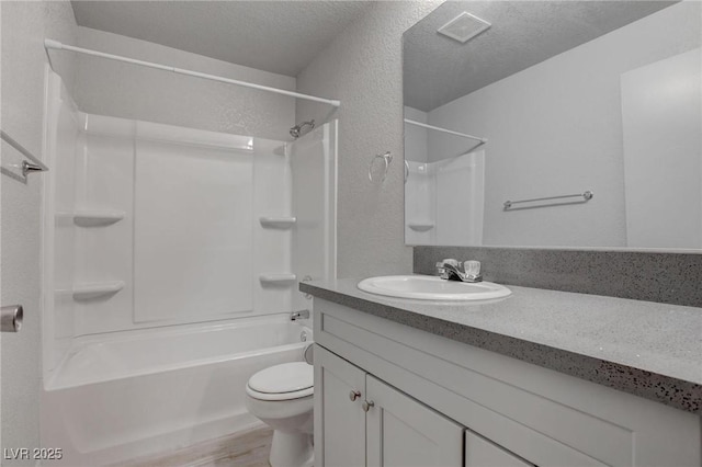 bathroom featuring a textured ceiling, a textured wall, toilet, and visible vents