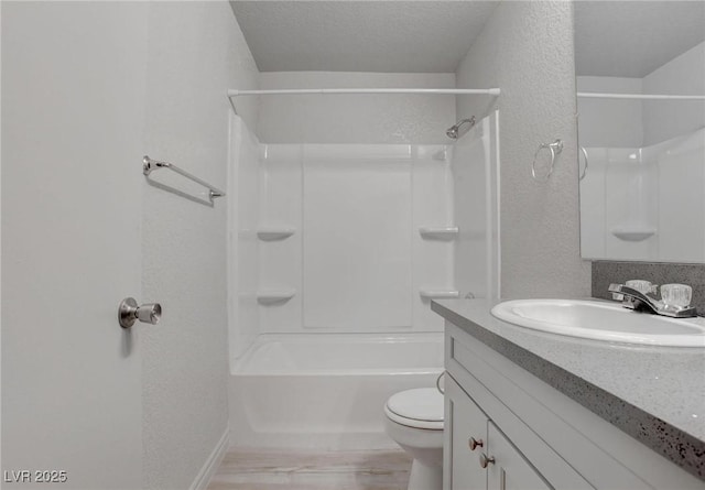 full bath featuring a textured wall, toilet, wood finished floors, a textured ceiling, and vanity