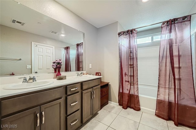 bathroom featuring double vanity, visible vents, a sink, and tile patterned floors