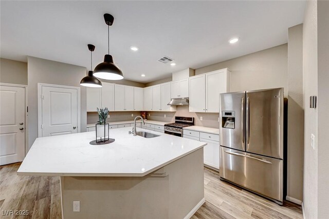 kitchen with visible vents, light wood-style flooring, stainless steel appliances, under cabinet range hood, and a sink