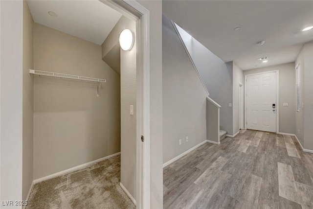 hall with stairway, wood finished floors, and baseboards