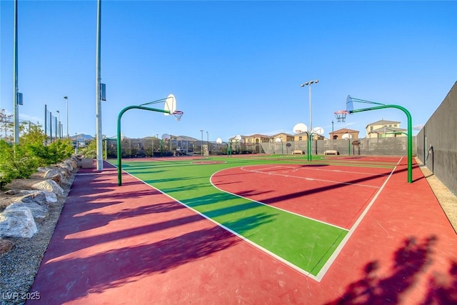 view of basketball court featuring a residential view, community basketball court, and fence