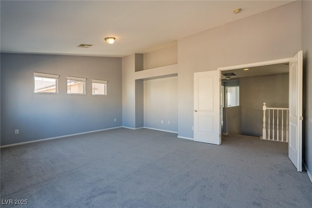 unfurnished bedroom with carpet flooring, baseboards, visible vents, and high vaulted ceiling