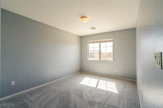 carpeted empty room featuring baseboards and visible vents