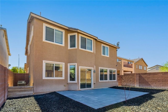 back of house with a patio area, a fenced backyard, and stucco siding