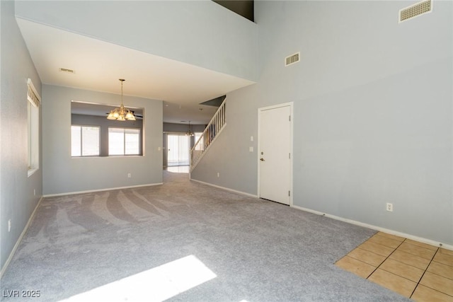 empty room featuring stairs, an inviting chandelier, and visible vents