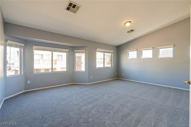 carpeted spare room with visible vents, baseboards, and vaulted ceiling