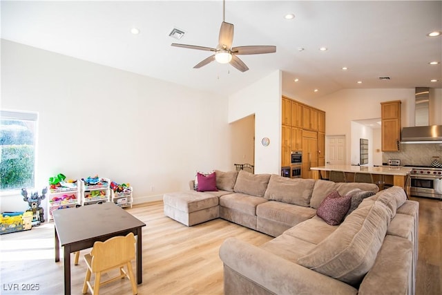 living area with visible vents, a ceiling fan, light wood-style floors, high vaulted ceiling, and recessed lighting