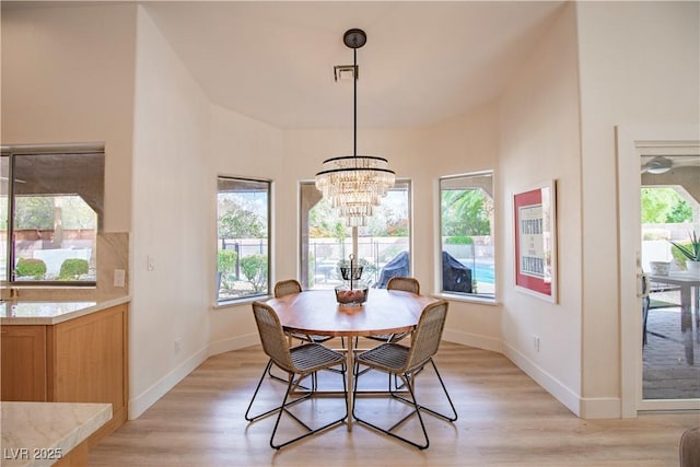 dining space featuring a wealth of natural light, light wood-style flooring, and baseboards