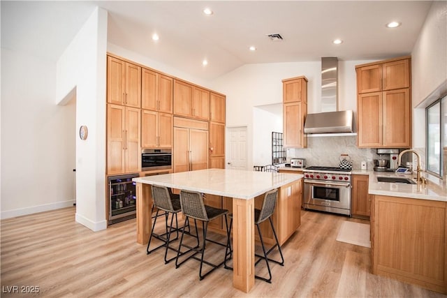 kitchen with wine cooler, visible vents, a kitchen island, high quality appliances, and wall chimney exhaust hood