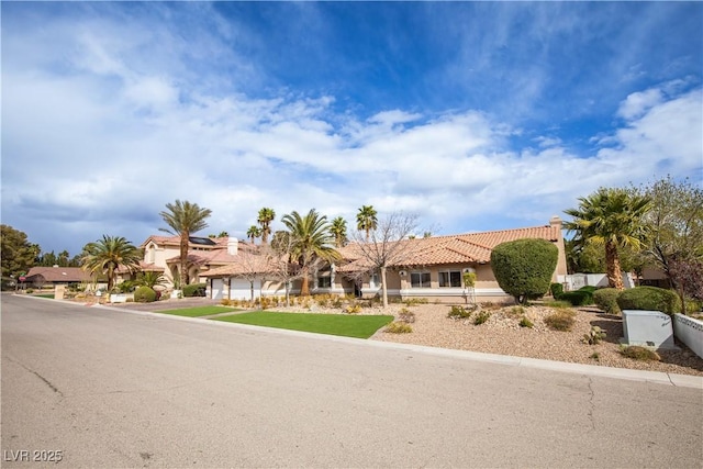 view of front of property with fence, a tile roof, a residential view, and stucco siding