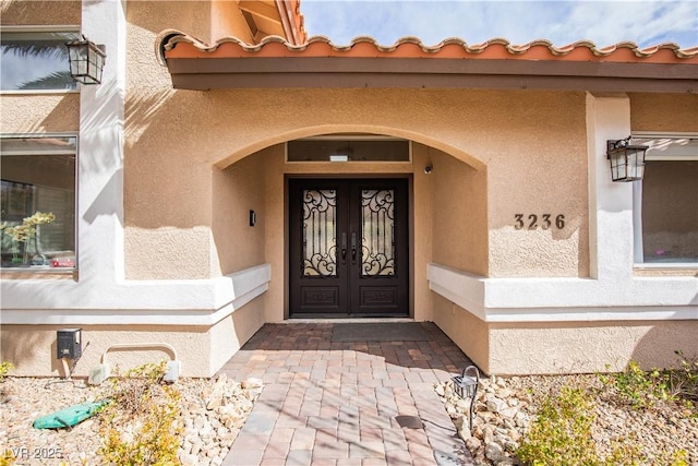 entrance to property with french doors and stucco siding