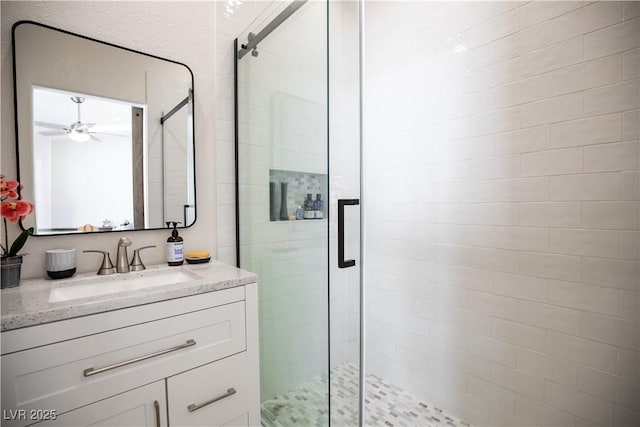 full bath featuring a ceiling fan, a shower stall, and vanity