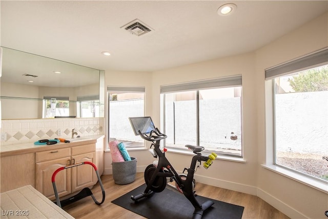 workout area featuring recessed lighting, light wood-type flooring, visible vents, and baseboards