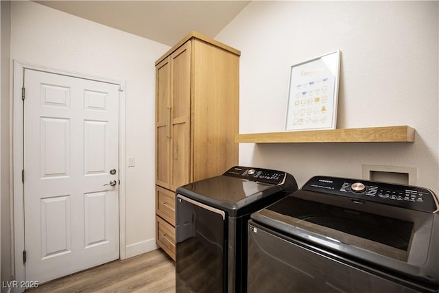 laundry room with light wood-style flooring, cabinet space, washer and clothes dryer, and baseboards