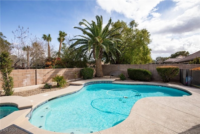 view of swimming pool with a pool with connected hot tub and a fenced backyard