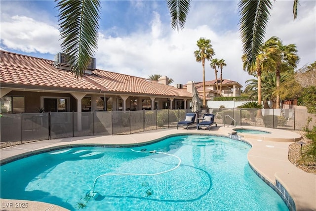 view of pool with a fenced in pool, fence, and an in ground hot tub