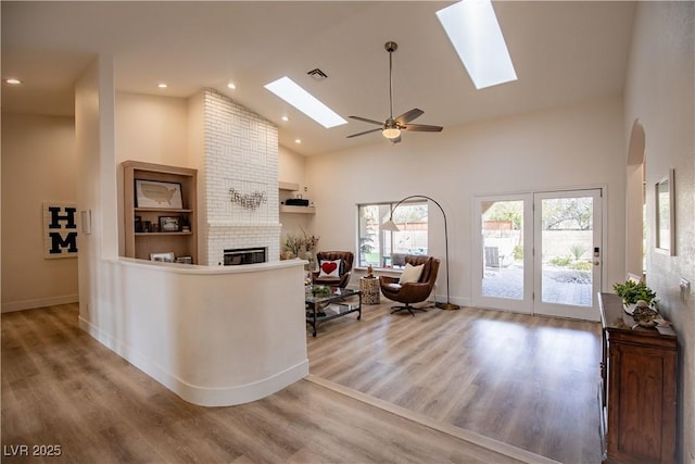 welcome area featuring a skylight, a fireplace, visible vents, and a ceiling fan