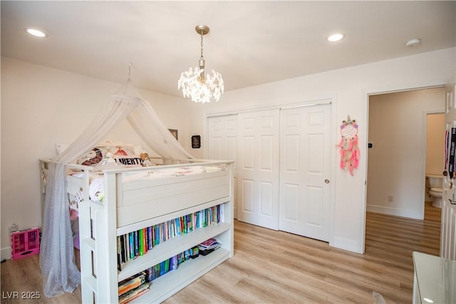 bedroom with light wood-style floors, a notable chandelier, a closet, and recessed lighting