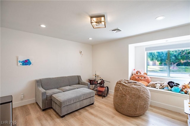 sitting room with recessed lighting, baseboards, visible vents, and light wood finished floors