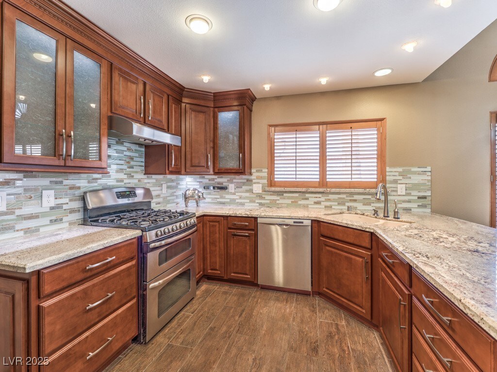 1276 Spanish Armada Rd, Las Vegas, NV 89123 - kitchen with a sink, under cabinet range hood, appliances with stainless steel finishes, and dark wood-style floors