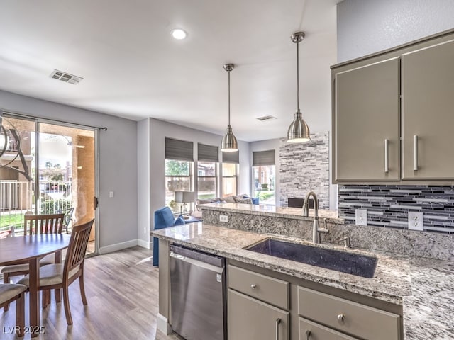 kitchen featuring visible vents, gray cabinets, a sink, decorative backsplash, and stainless steel dishwasher