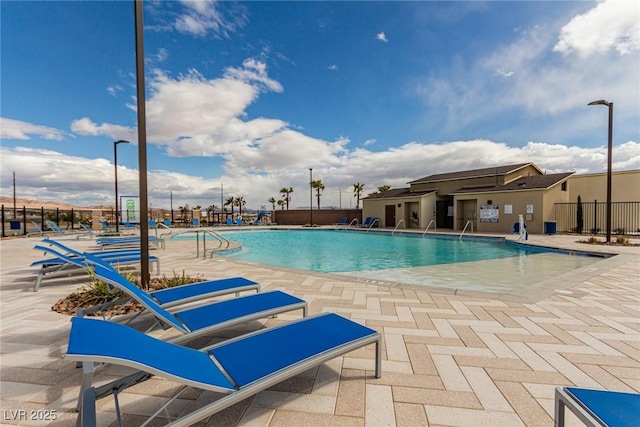 pool with a patio area and fence