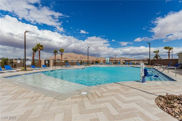 pool with a patio area and fence