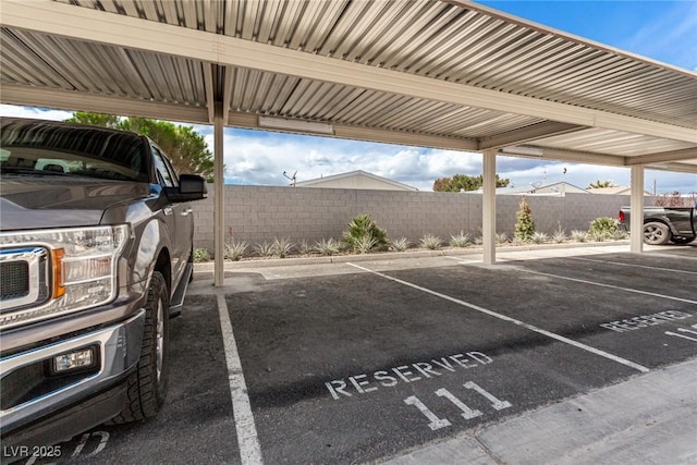 covered parking lot featuring fence