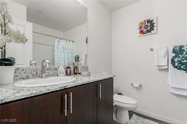 bathroom featuring baseboards, toilet, a shower with curtain, wood finished floors, and vanity