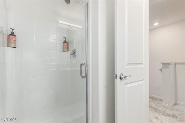 bathroom with a shower stall and baseboards