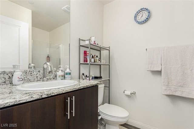 full bath with visible vents, toilet, a stall shower, vanity, and baseboards