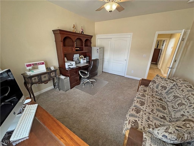 carpeted office featuring ceiling fan and baseboards