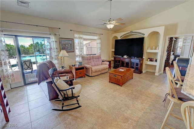 living area featuring lofted ceiling, a ceiling fan, visible vents, and a healthy amount of sunlight