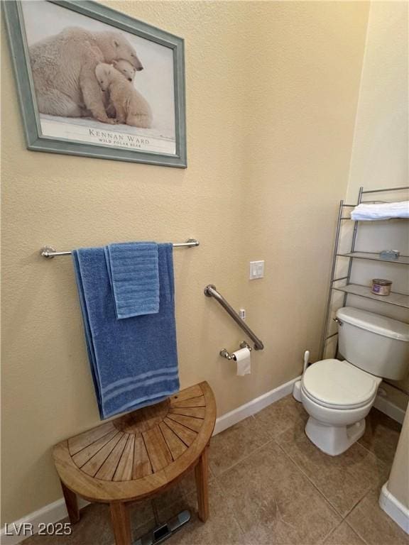 bathroom with baseboards, toilet, and tile patterned floors