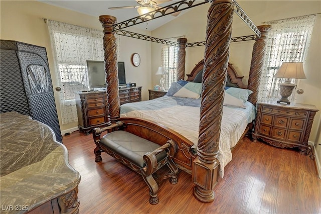 bedroom with lofted ceiling, multiple windows, and wood finished floors