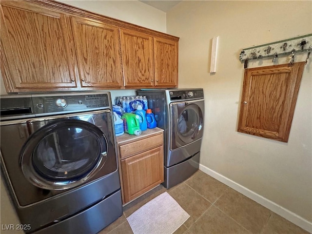 clothes washing area with baseboards, tile patterned floors, cabinet space, and washer and dryer