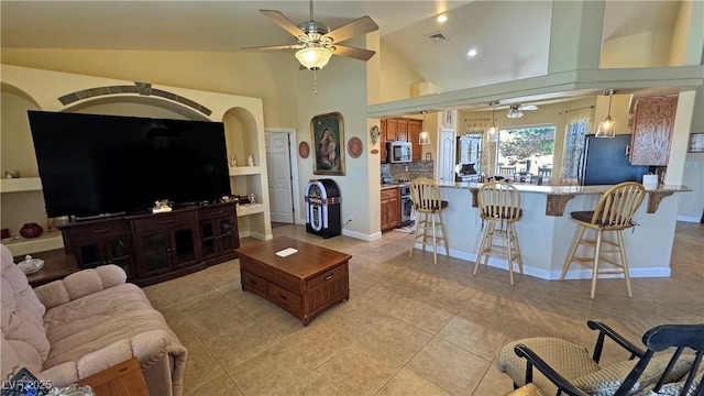 living area featuring light tile patterned floors, ceiling fan, visible vents, and baseboards