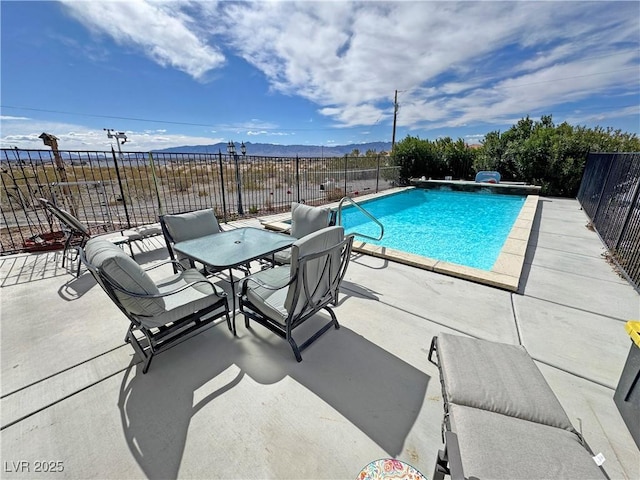 view of pool featuring a mountain view, a patio, fence, and a fenced in pool