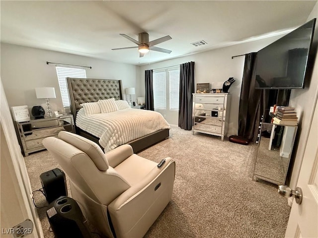 carpeted bedroom featuring a ceiling fan and visible vents