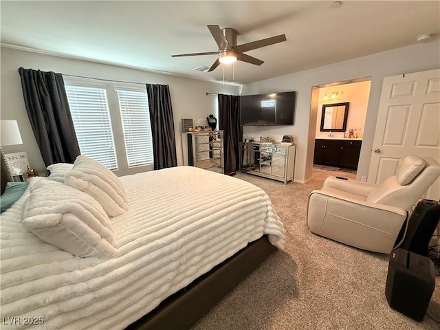 bedroom featuring a ceiling fan, ensuite bath, visible vents, and light colored carpet