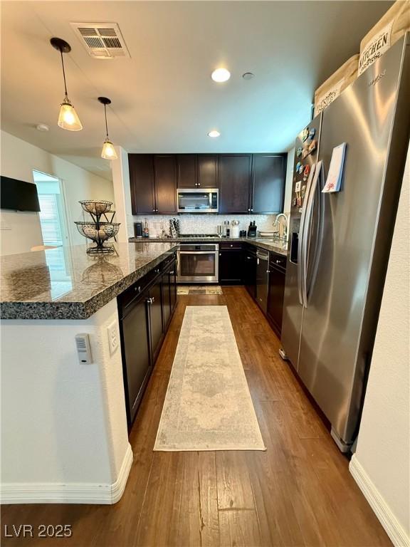 kitchen with a sink, visible vents, stainless steel appliances, and dark wood-style flooring