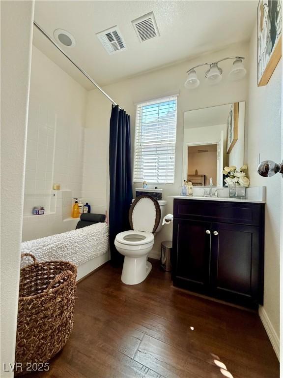 bathroom with toilet, visible vents, wood finished floors, and vanity