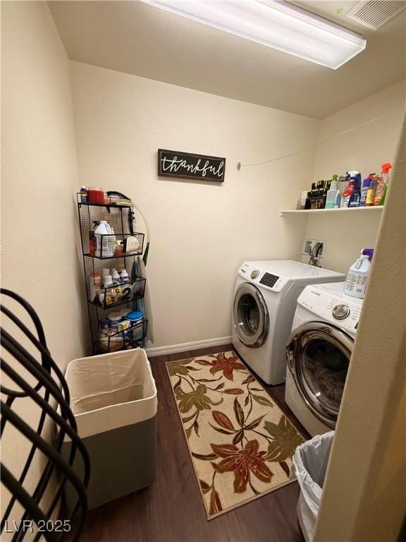 laundry room featuring laundry area, visible vents, separate washer and dryer, and wood finished floors