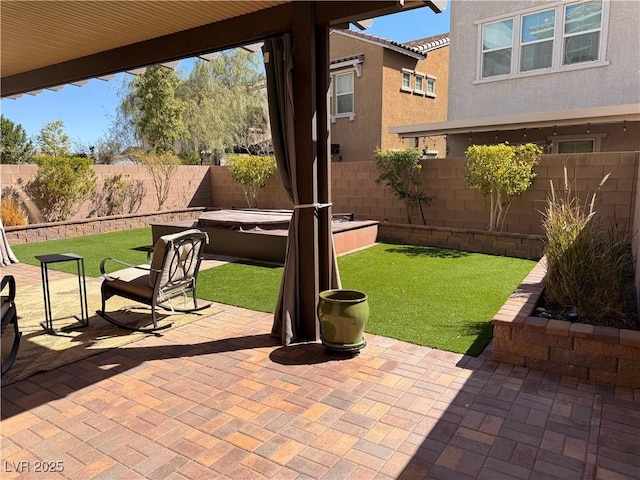 view of patio with a fenced backyard and a hot tub