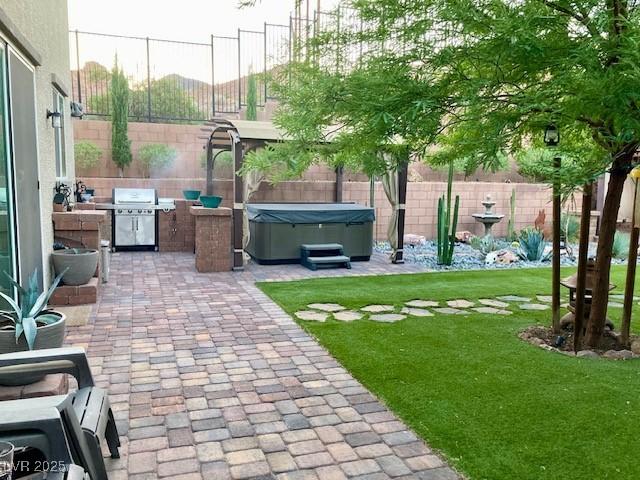 view of yard featuring a patio, a fenced backyard, and a hot tub